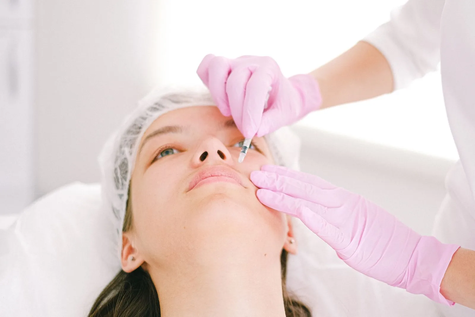 Woman receiving a facial cosmetic injection while comparing botox vs fillers at a Malta clinic
