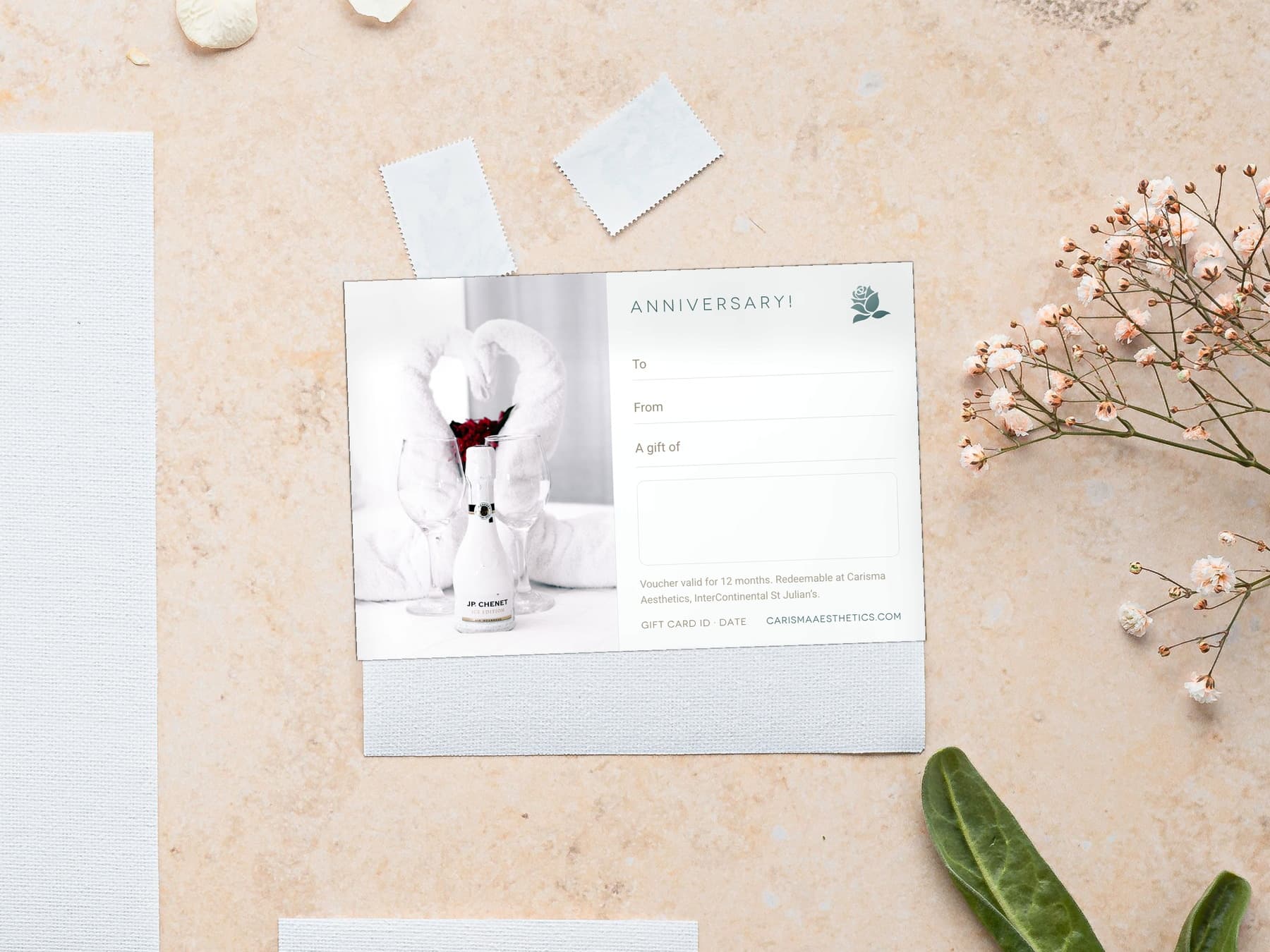 A Carisma Aesthetics anniversary gift card laid on cool marble