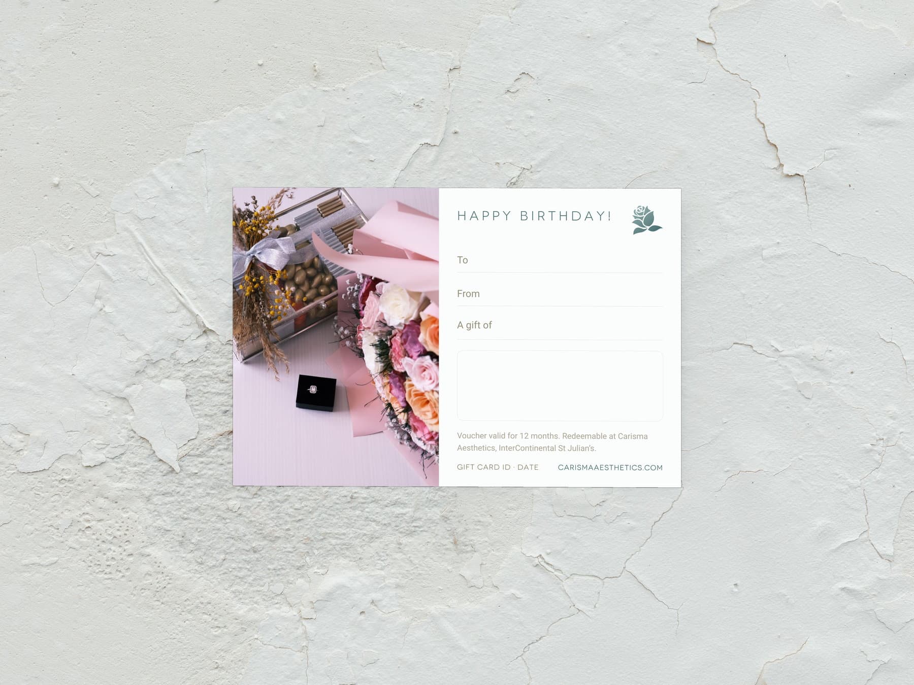 A Carisma Aesthetics birthday gift card laid on white plaster