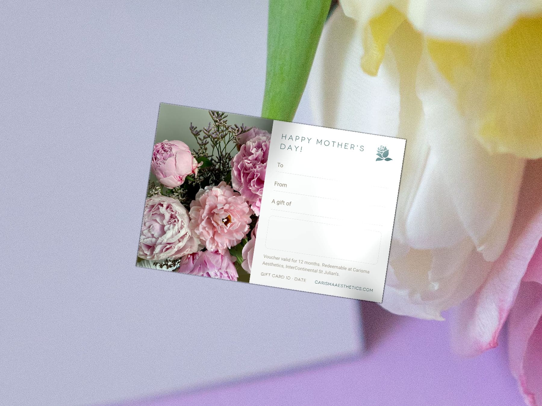 A Carisma Aesthetics Mother's Day gift card on pale stone with cream roses and gypsophila