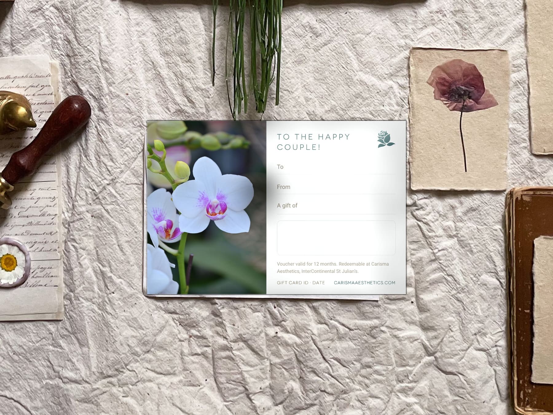 A Carisma Aesthetics gift card between dried palm fans on a pale ivory ground